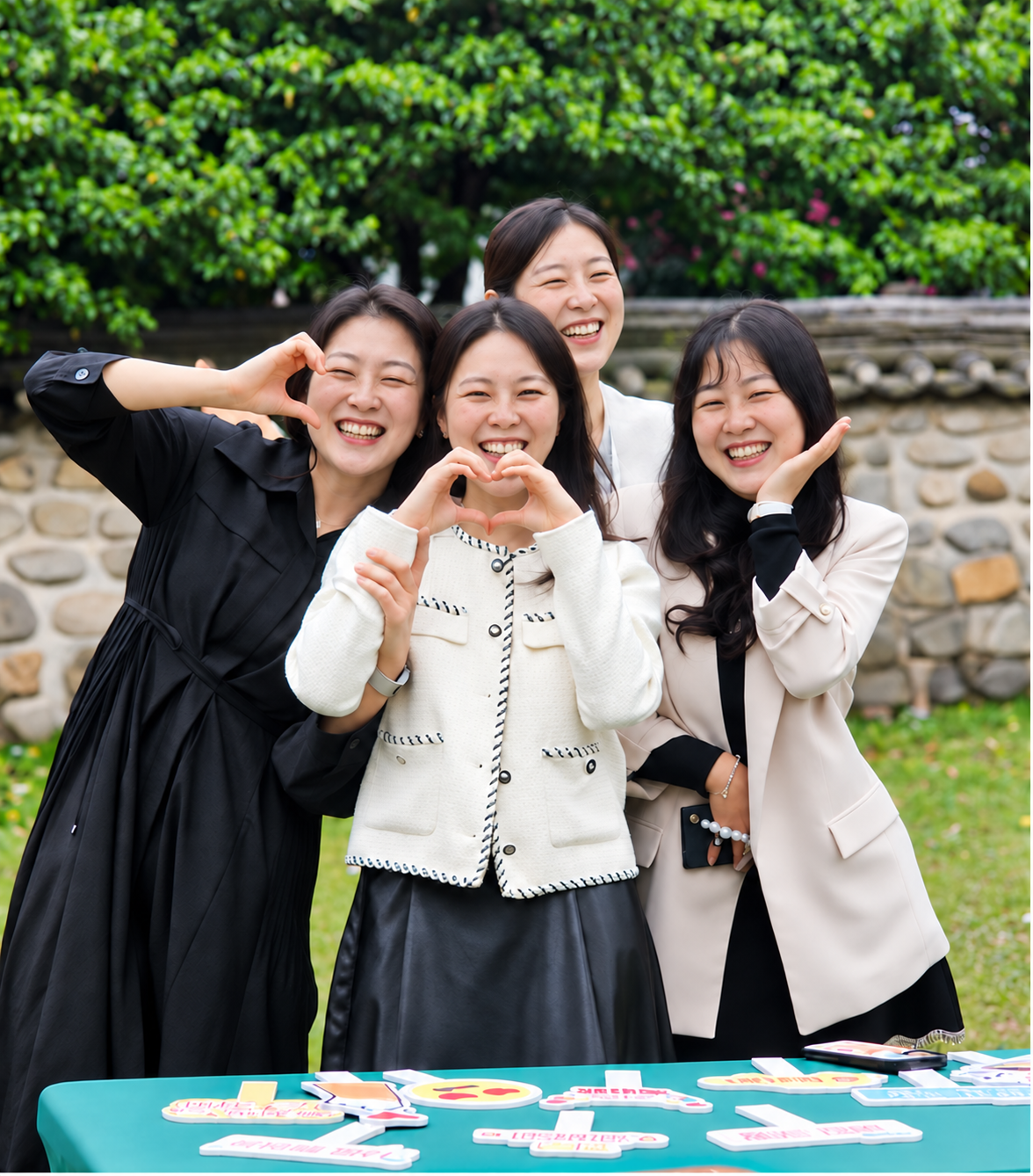 야외 웨딩에서 하트 포즈를 하며 웃는 친구들의 얼굴 편집 이미지